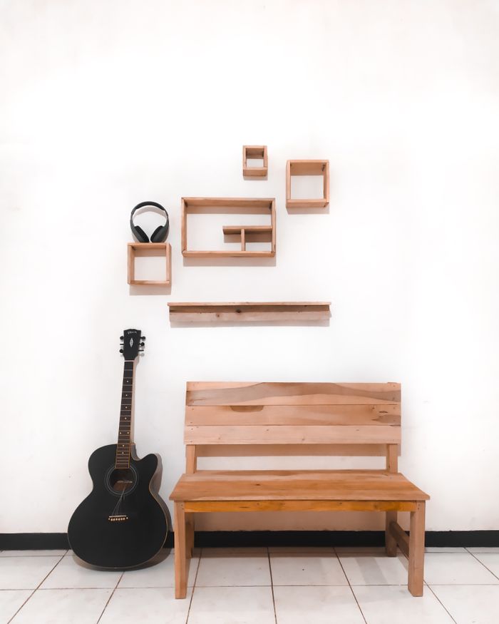 services-img Minimalist setup featuring an acoustic guitar and wooden bench against a decorated wall.