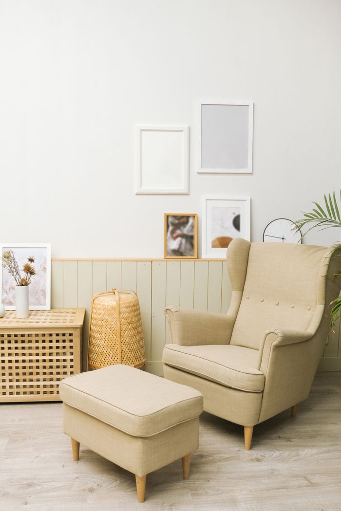 services-02 Cozy living room with beige armchair, pouf, and minimalist decor.