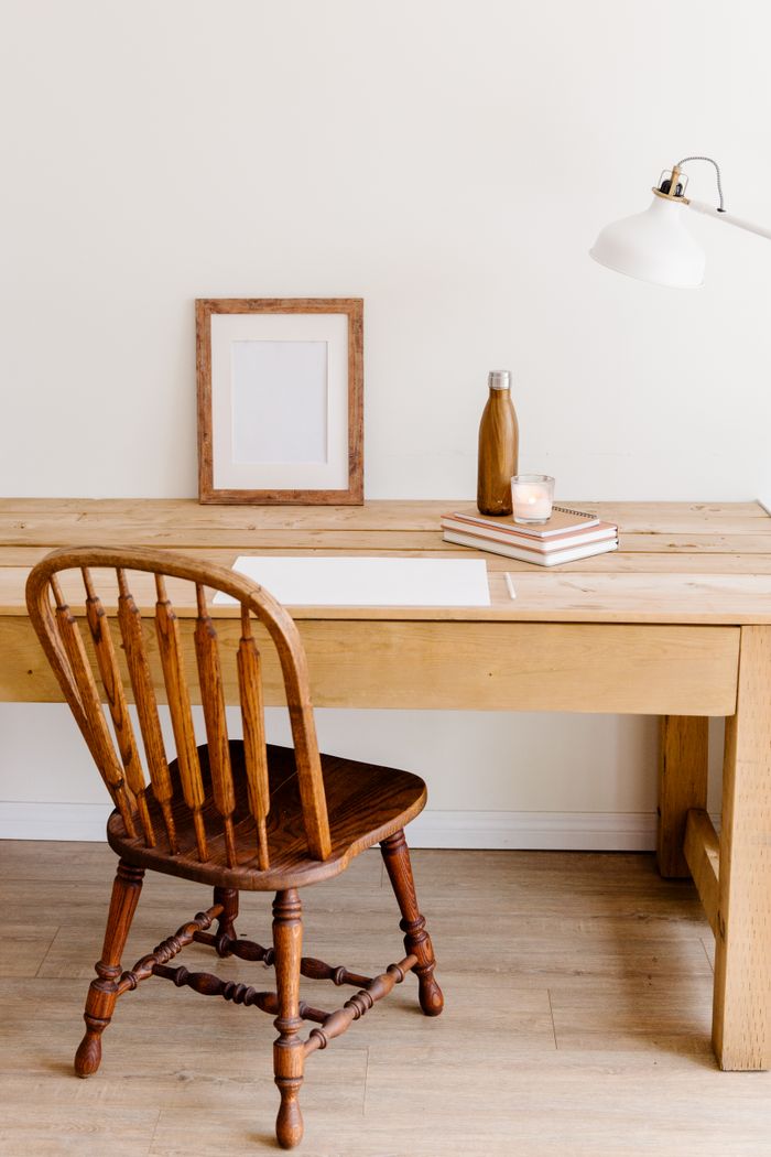 services-03 Minimalist workspace setup with a wooden desk, chair, and simple decor elements.