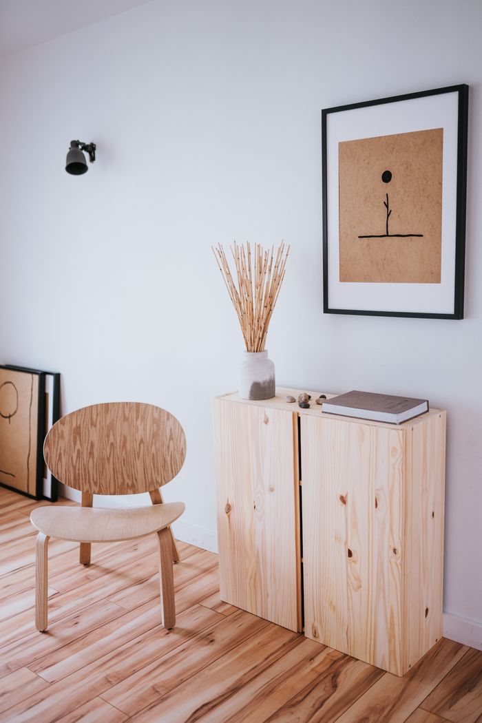 A serene Japandi-style room features wooden furniture and minimalist art, creating a calm, uncluttered space.