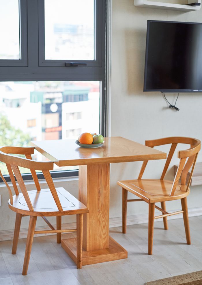 ours-journey Bright dining area in a Hanoi apartment with wooden table and chairs, perfect for cozy meals.